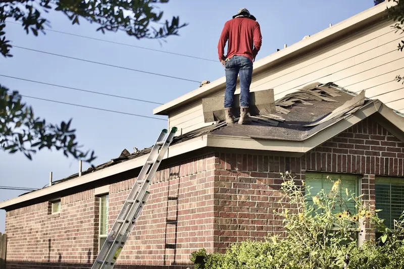Professional roofer working on a residential roof in Haverwood